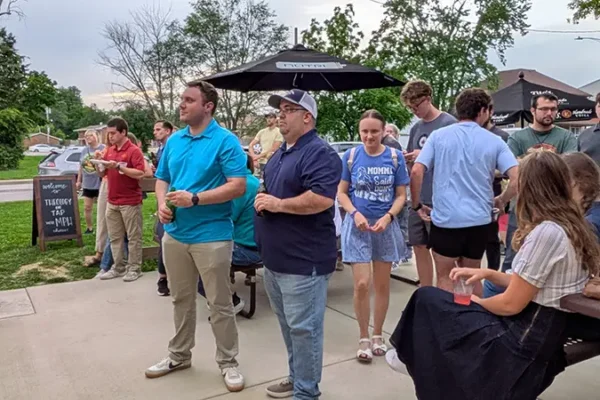 people listening to priest during event in maryville il