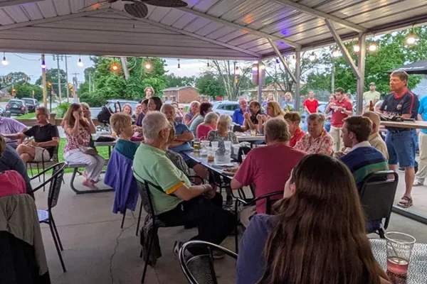 people listening to priest during event in maryville il