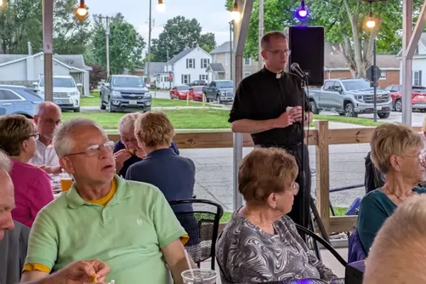 priest talking to people during event in maryville il